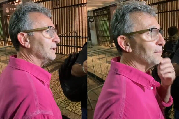 Neto vestido uma blusa rosa, em trechos da entrevista na porta da Vila Belmiro