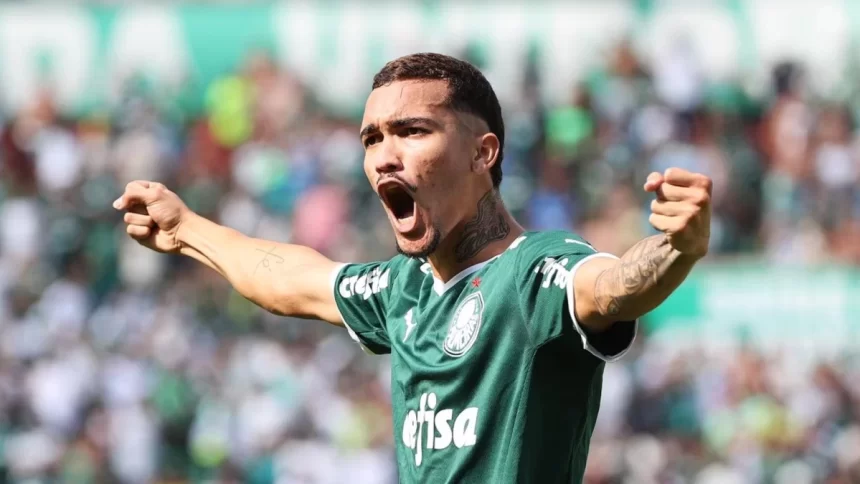 Jogador Ruan Ribeiro, com os braços abertos, comemorando um gol com a camisa do Palmeiras