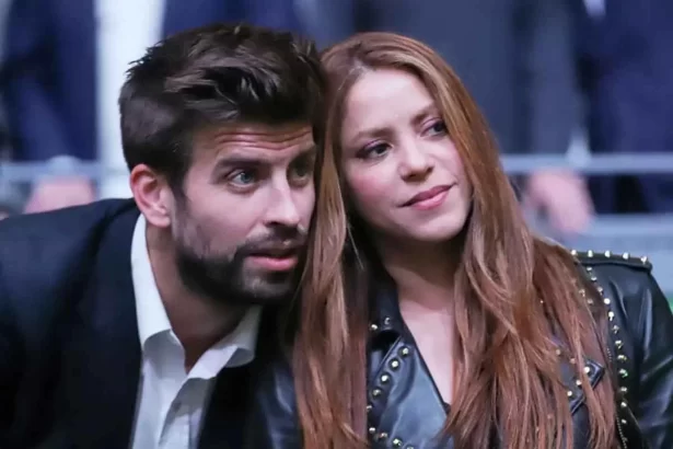 Shakira com blazer de couro preto, cabelo ruivo, solto, ao lado de Gerard Piqué, com a cabeça encostada no ombro