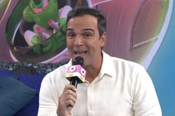 Tadeu Schmidt de camisa branca e calça dentro da Casa de Vidro, apresentando o espaço em chamada