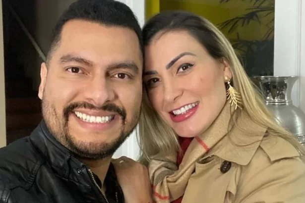 Thiago Lemos de camisa preta, sorrindo, ao lado de Andressa Urach de sobretudo marrom