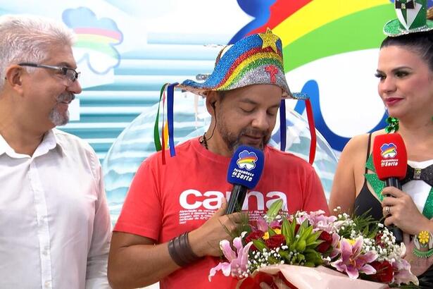 Beto Café segurando um buquê de flores ao lado de outros apresentadores do Pernambuco dá Sorte