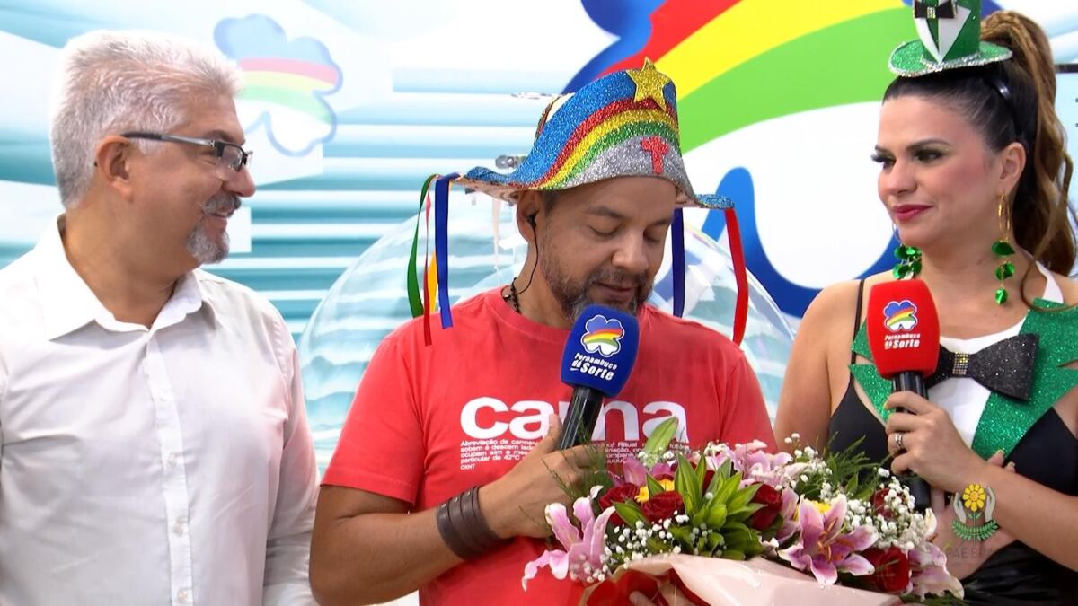 Beto Café segurando um buquê de flores ao lado de outros apresentadores do Pernambuco dá Sorte