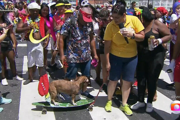 Bianka Carvalho de bermuda e camisa amarela andando de skate com cachorro na rua