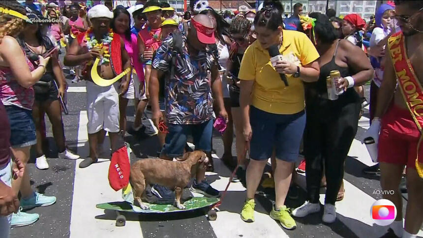 Bianka Carvalho de bermuda e camisa amarela andando de skate com cachorro na rua