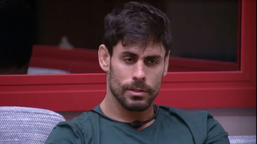 Cara de Sapato de camisa cinza, sentado no sofá, na sala do BBB 23, da TV Globo