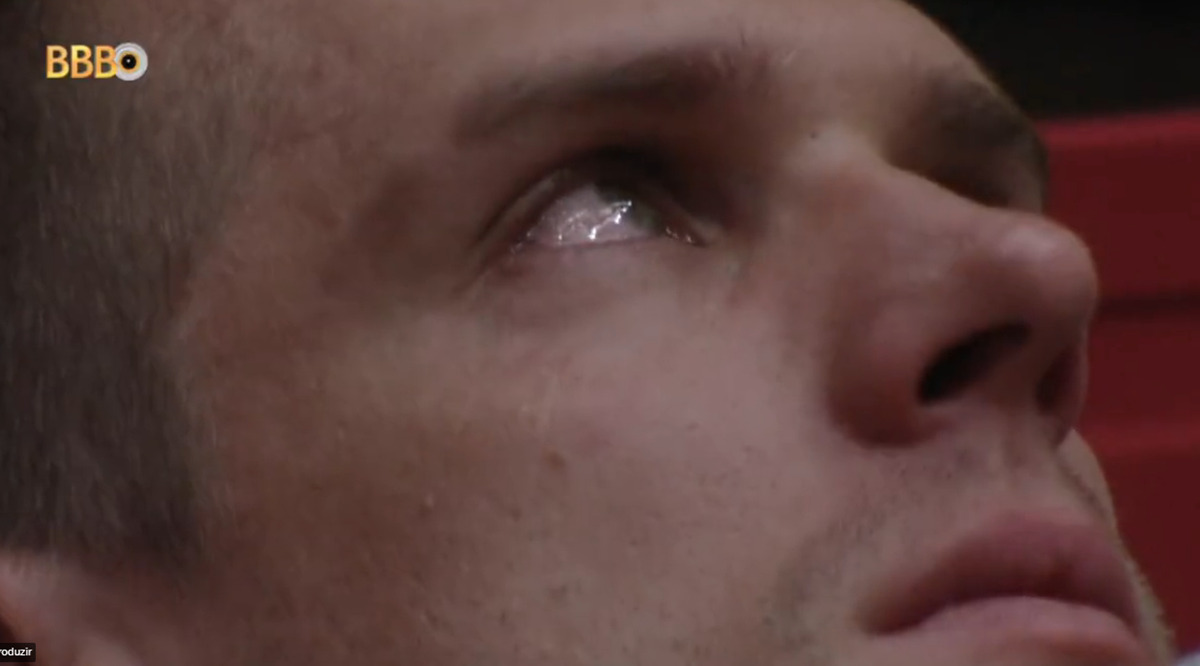 Cristian olhando pra cima, com lágrimas nos olhos