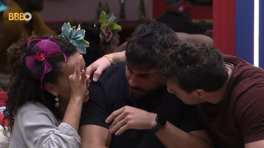 Domitila sentada ao lado de Gustavo e Cara de Sapato, no sofá do BBB 23