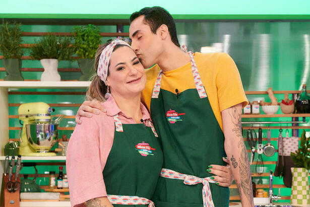 Douglas Souza e Elisangela, sua mãe, abraçados, em trecho do reality Minha Mãe Cozinha Melhor Que a Sua, na cozinha verde