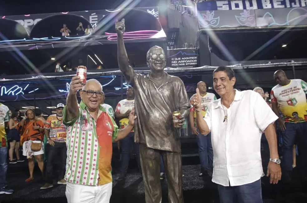 Zeca Pagodinho e Jayder Soares posando ao lado da estátua em tamanho real do cantor