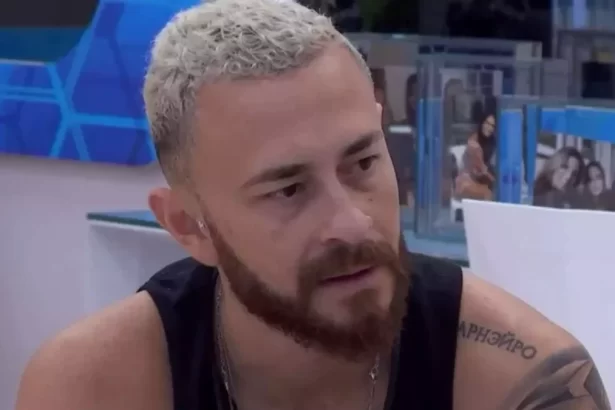 Fred Desimpedidos de regata preta, sentado na mesa do VIP do BBB 23