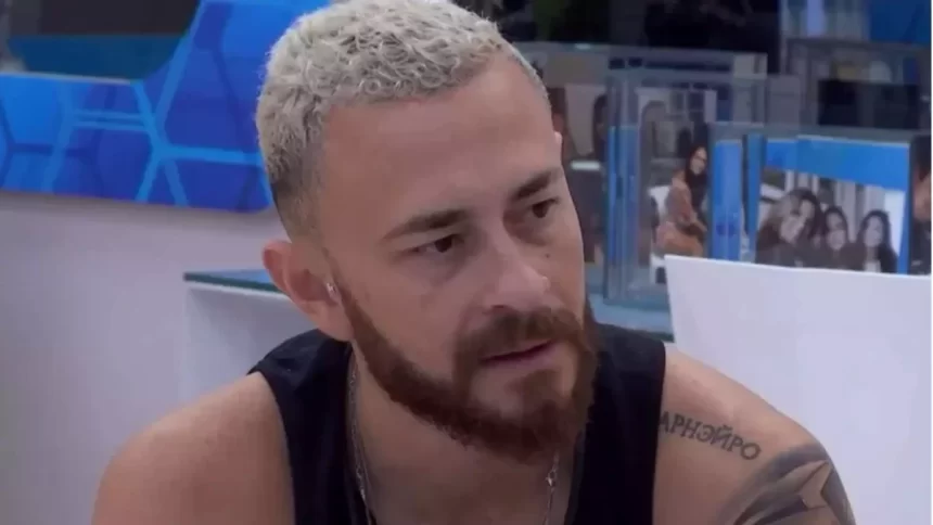 Fred Desimpedidos de regata preta, sentado na mesa do VIP do BBB 23