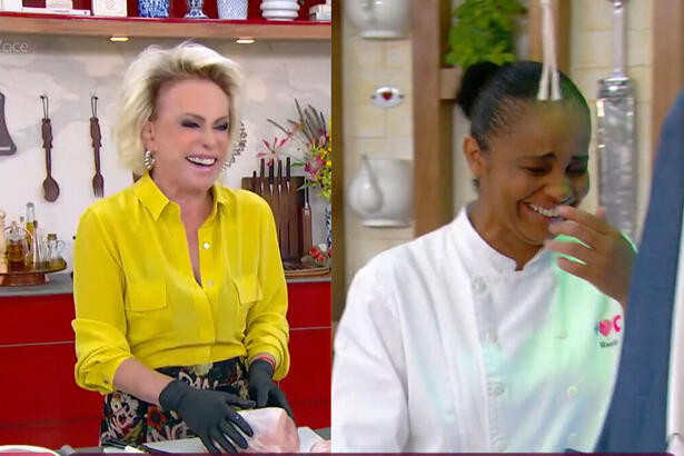 Ana Maria Braga segurando o lombo suíno com a linguiça dentro e sorrindo, ao lado a sua assistente também cai na gargalhada com a piada da apresentadora do Mais Você