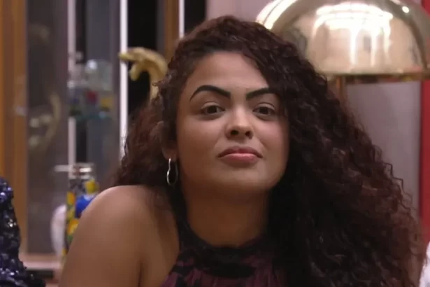 Paula olhando pra frente, sentada, cabelo solto, durante eliminação no BBB 23