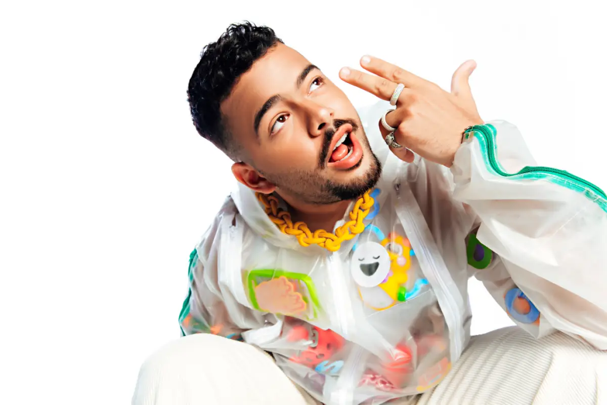 Pedro Sampaio de blazer branco com adereços colorido durante ensaio fotográfico para single
