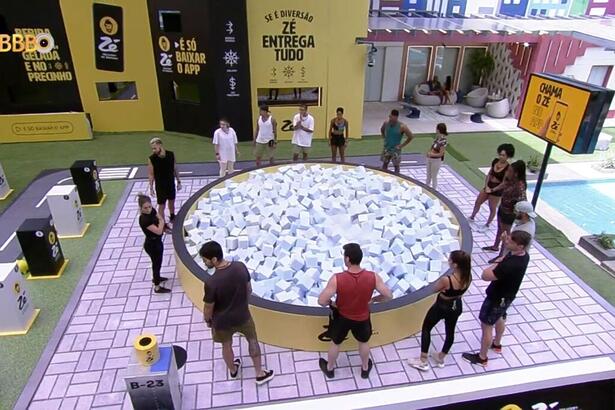 Participantes do Big Brother Brasil em volta de uma piscina de cubo na área externa da casa