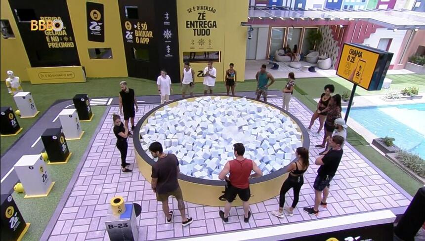 Participantes do Big Brother Brasil em volta de uma piscina de cubo na área externa da casa