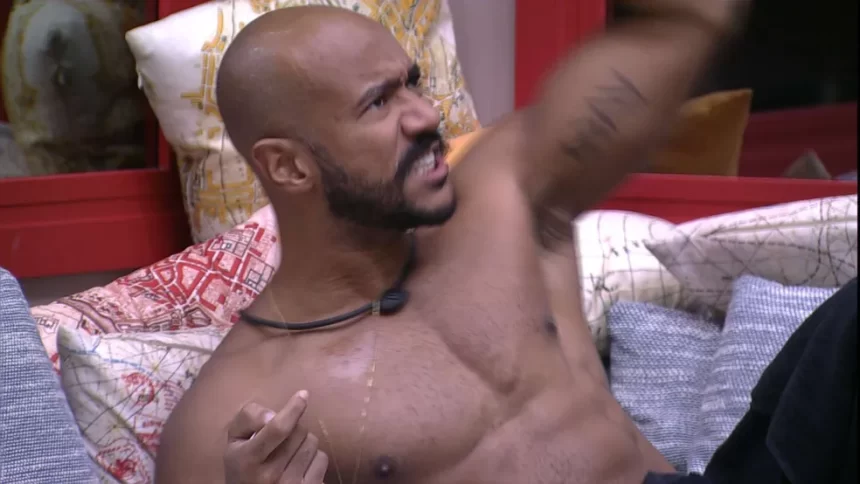 Ricardo Camargo sem camisa, com semblante de bravo, deitado no sofá do BBB 23