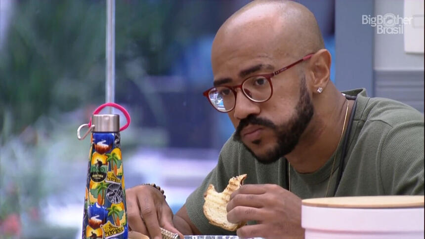 Ricardo comendo pão na cozinha do BBB 23