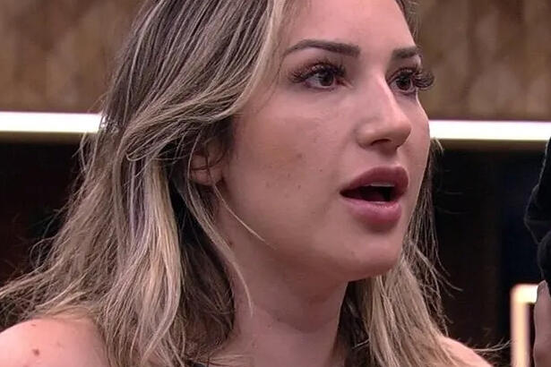 Amanda com o dedo pra frente, boca aberta, cabelo banhado