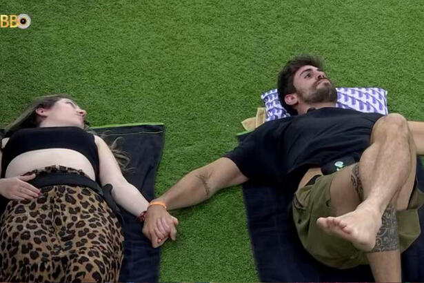 Amanda e Cara de Sapato deitados no jardim do BBB 23 enquanto conversam