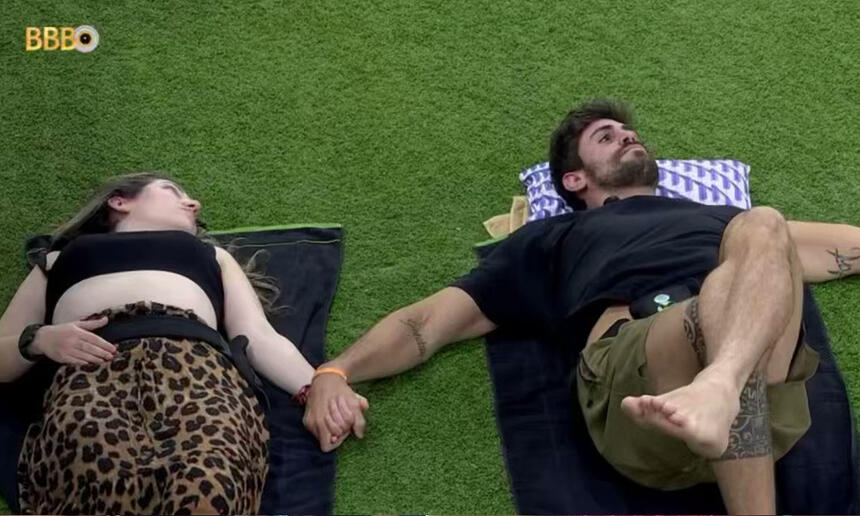 Amanda e Cara de Sapato deitados no jardim do BBB 23 enquanto conversam