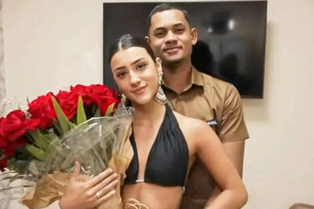 Bia Miranda e Gabriel Roza, abraçados em foto posada. Ela segura um arranjo de rosas