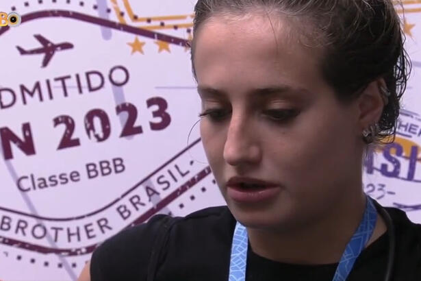 Bruna Griphao de camisa preta e cabeça baixa na dispensa do BBB 23