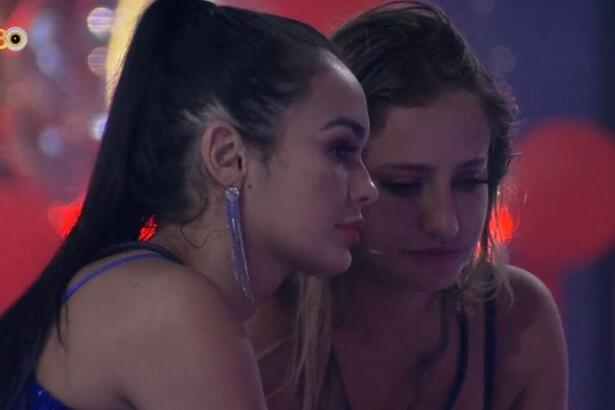 Larissa e Bruna sentadas uma de frente para a outra durante festa do BBb 23.