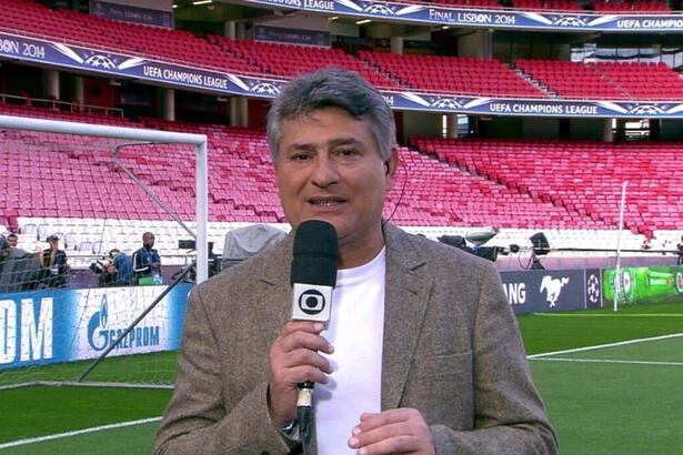 Cléber Machado no gramado de um estádio, nos bastidores de uma transmissão da Globo