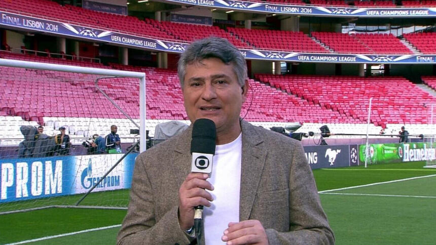 Cléber Machado no gramado de um estádio, nos bastidores de uma transmissão da Globo