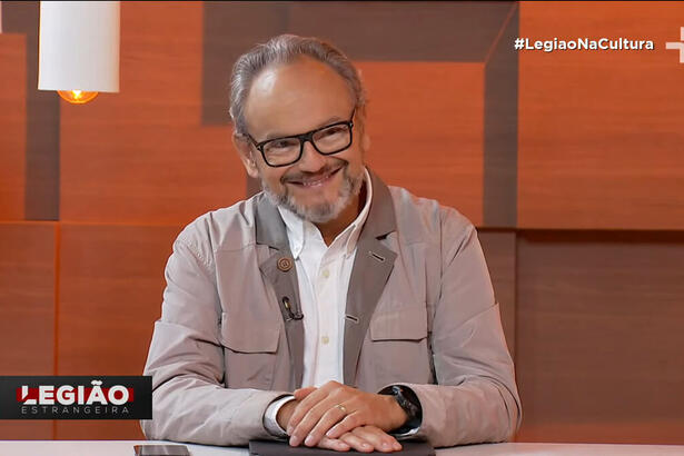 Ernesto Paglia sentado na bancada do programa Legião Estrangeira, na TV Cultura