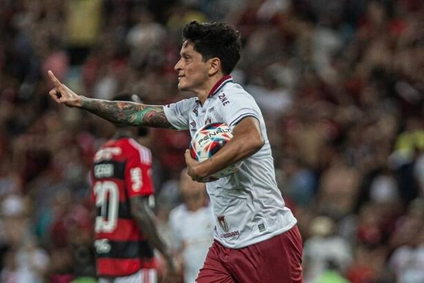 Jogador Cano, com a bola debaixo do braço, comemorando um gol com a camisa do Fluminense contra o Flamengo