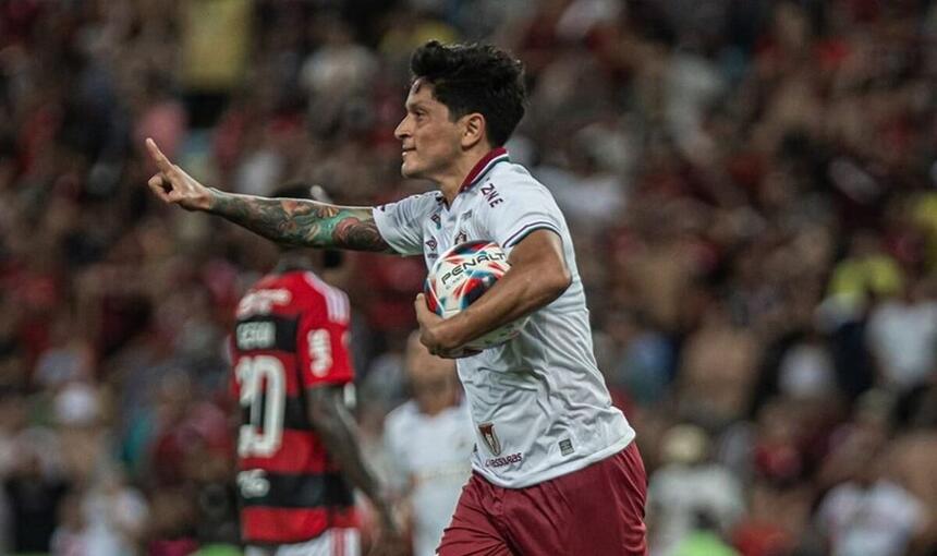 Jogador Cano, com a bola debaixo do braço, comemorando um gol com a camisa do Fluminense contra o Flamengo