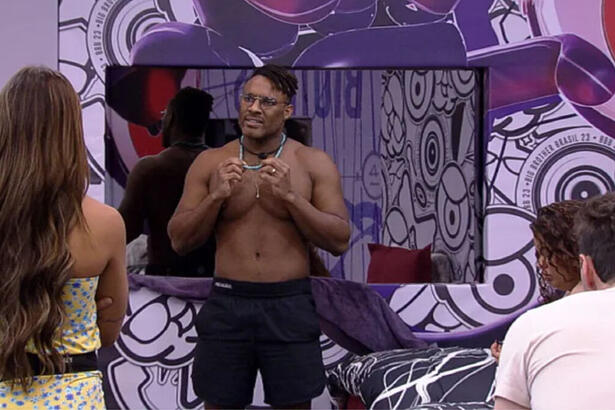 Fred Nicácio em pé na Casa do Reencontro do BBB 23 conversando, com Key e Gustavo de frente para ele de costas para a imagem