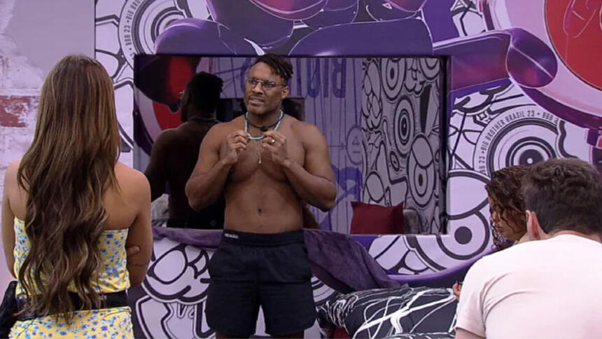 Fred Nicácio em pé na Casa do Reencontro do BBB 23 conversando, com Key e Gustavo de frente para ele de costas para a imagem