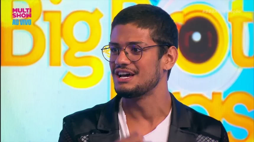 Gabriel Santana de jaqueta preta, camisa branca, oculos de grau durante gravação para o Multishow