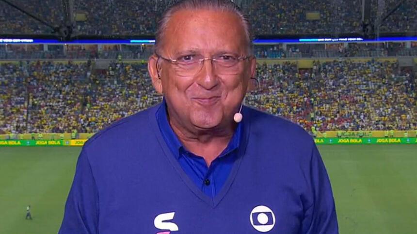 Galvão Bueno nos bastidores de uma transmissão da Globo, com um estádio ao fundo