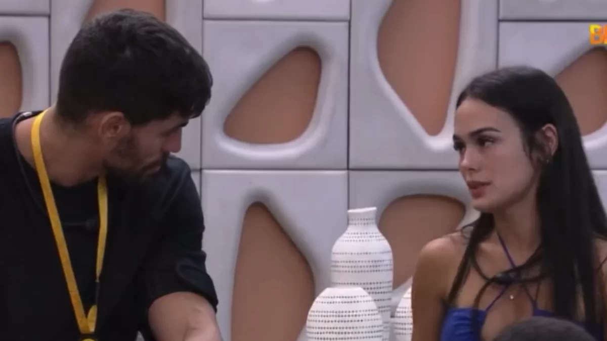 Larissa de camiseta azul em frente a Cara de Sapato, sentados, conversando