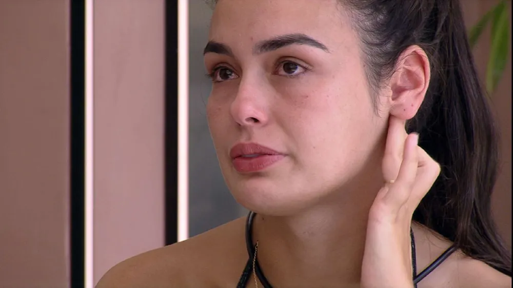 Larissa de cabelo preso, chorando, sentada, em conversa com Marvvila na varanda do BBB 23