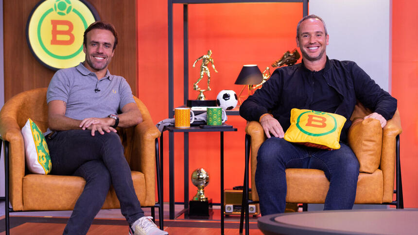 Roger Flores e Caio Ribeiro sentados em poltronas, no novo cenário do Boleiragem do SporTV