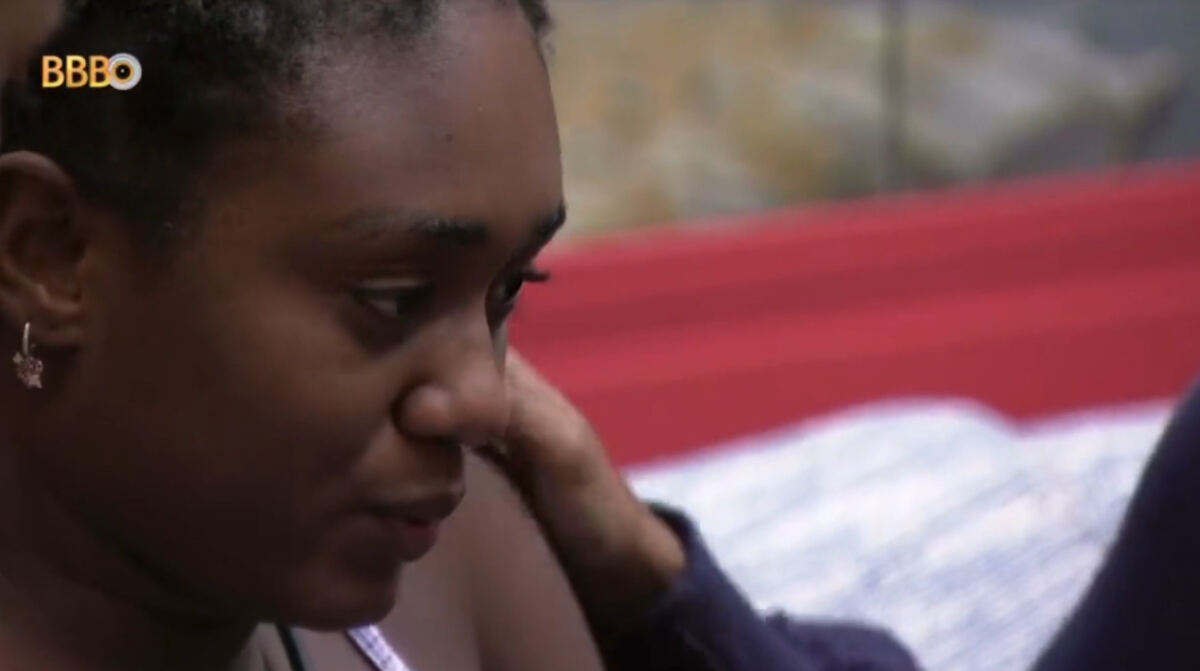 Sarah do BBB 23 sentada no sofá tendo crise de ansiedade