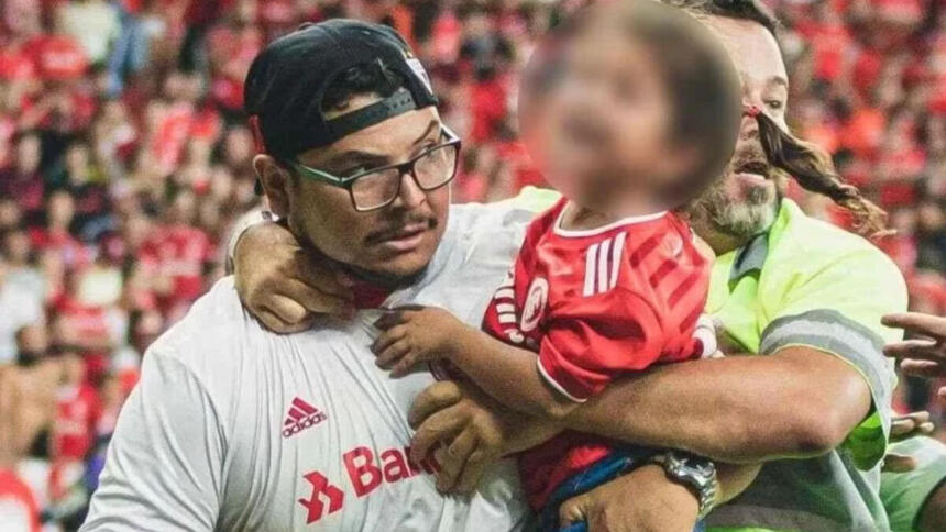 Torcedor do Internacional, com uma criança no colo, sendo retirado por seguranças após invadir o gramado