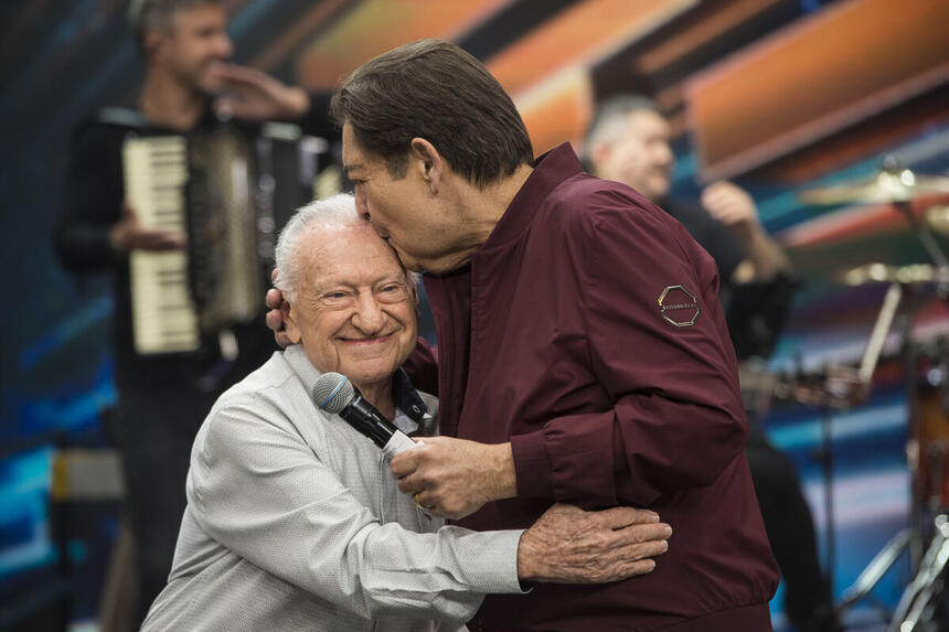 Faustão beija violinista de 90 anos na cabeça, no palco do Faustão na Band