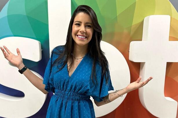 Amanda Neves posa em frente ao logo do SBT na TV Jornal Recife