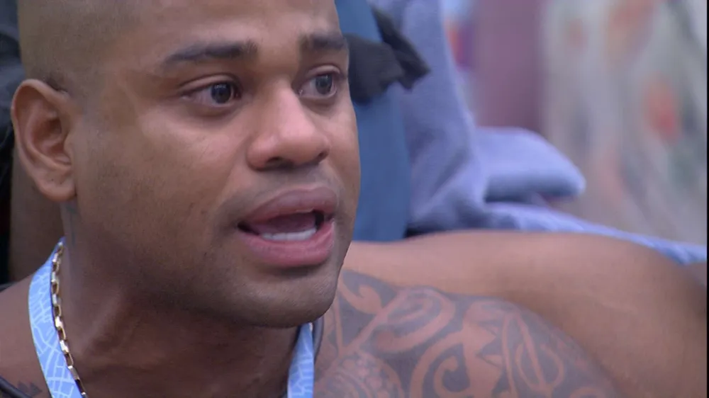 Cezar Black chorando no Quarto Fundo do Mar, sem camisa, com colar azul no pescoço
