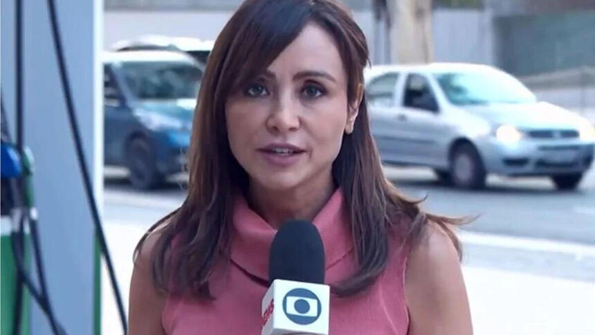 Elaine Bast em trecho de uma reportagem na rua, com o microfone da Globo em mãos