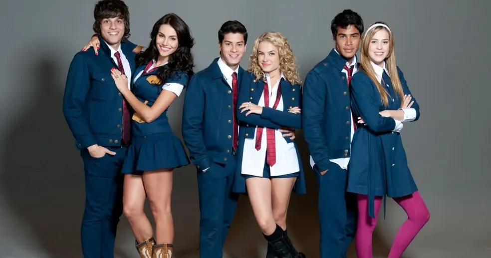 Chay Suede, Mel Fronckowiak, Arthur Aguiar, Lua Blanco, Micael e Sophia Abrahão em foto posada de Rebelde, vestido com as roupas dos personagens 