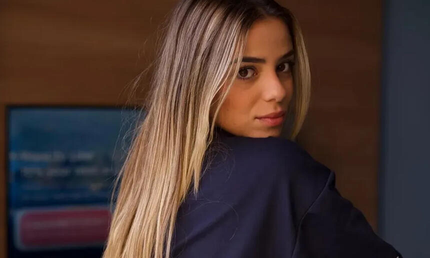 Key Alves de cabelo solto, loiro, de perfil, sentada durante ensaio sensual