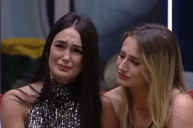 Larissa chorando, sentada, ao lado de Bruna Griphao no sofá do BBB 23